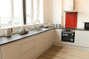una cucina con lavandino e piano cottura forno superiore di Modern Luxury Serviced Duplex Apartments by REPOSE- 150 Metro Court, WEST BROMWICH a West Bromwich
