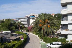 een straat met een palmboom en een gebouw bij GUEST HOUSE LANA 1 in Split