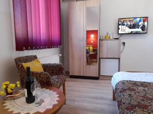 Pokój z łóżkiem i stołem z butelką wina w obiekcie Sobe i apartmani Kety w mieście Kragujevac