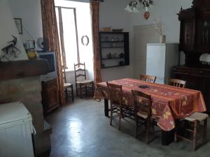 uma cozinha com mesa e cadeiras num quarto em Maison de caractère- grand appartement en location em Pompidou
