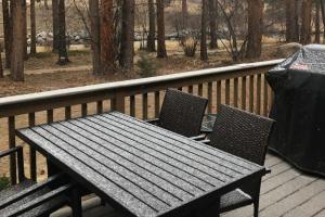 a picnic table and two chairs on a deck at River Retreat - Permit #3517 in Estes Park