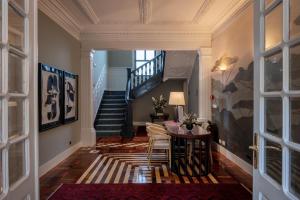 a hallway with a staircase and a table with chairs at Casa da Marechal - Boutique Hotel by Oporto Collection - Adults Only in Porto