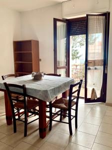 d'une table à manger, de chaises, d'une table et d'une fenêtre. dans l'établissement "La Casa di FRILA" Bilocali a Borgo Celano, à San Giovanni Rotondo