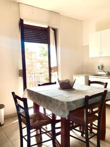 une table et des chaises dans une cuisine avec une table et une fenêtre dans l'établissement "La Casa di FRILA" Bilocali a Borgo Celano, à San Giovanni Rotondo