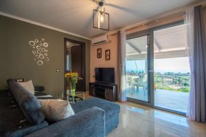 sala de estar con sofá azul y puerta corredera de cristal en The View Villa, en Maryiés