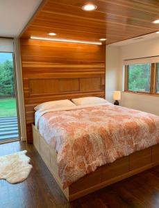 a bedroom with a large bed with a wooden wall at Rig Veda House - Saratoga Estate Property 