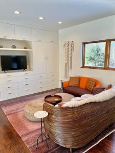 a living room with a couch and a tv at Rig Veda House - Saratoga Estate Property 
