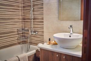 a bathroom with a sink and a bath tub at Pelagaki Sunrise in Orthoniaí