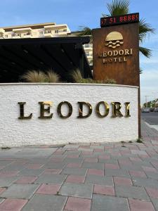 a sign for a hotel in front of a building at LEODORI 3 suites in Shëngjin