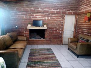uma sala de estar com um sofá e uma parede de tijolos em CABAÑA LA GRULLA em Santa Verónica