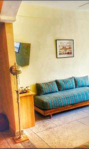 a living room with a blue couch and a lamp at Dar Agadir in Agadir