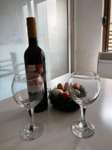a bottle of wine and two wine glasses on a counter at Cosy apartment in Mavrovo in Mavrovo