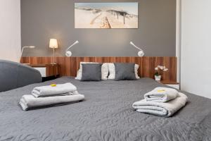 um quarto com uma cama grande e toalhas em Superior Apartment with big terrace and parking Zablocie em Cracóvia