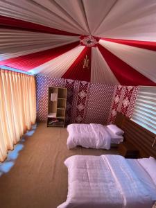 a room with two beds and a red and white ceiling at rum rema camp in Wadi Rum