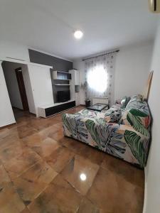 uma sala de estar com um sofá e uma cama em Anfitrión particular em Castellón de la Plana