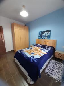 1 dormitorio con 1 cama con manta azul y blanca en Anfitrión particular, en Castellón de la Plana