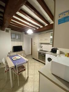 eine Küche mit einem Tisch und eine Küche mit einem Herd in der Unterkunft Casa Maria in Portoferraio