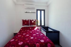 Un dormitorio con una cama roja con sábanas de lunares. en Appartamento Ginny Dachi Farm, en Andora