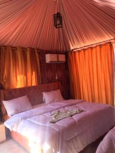 a bedroom with a large bed in a tent at rum rema camp in Wadi Rum
