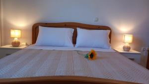a bed with two lamps and a flower on it at Korali in Symi