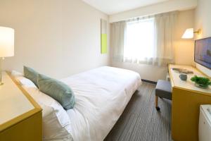 a hotel room with a large bed and a desk at Hotel Resol Machida in Machida
