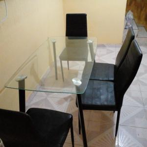 une table en verre avec deux chaises noires, une table en verre et deux chaises dans l'établissement Casa en Joyas Cuautitlan grande y cómoda, à Cuautitlán