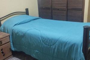 - une chambre avec un lit bleu et une tête de lit en bois dans l'établissement Casa en Joyas Cuautitlan grande y cómoda, à Cuautitlán