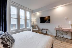 1 dormitorio con 1 cama, escritorio y ventanas en Hébergement touristique ▐ 335 Saint Joseph E▐, en Quebec