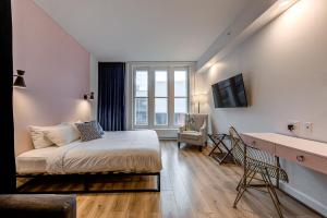 1 dormitorio con cama, escritorio y ventana en Hébergement touristique ▐ 335 Saint Joseph E▐, en Quebec