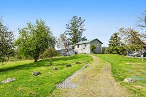 una casa en una colina con césped con un camino de tierra en Deer Harbor Cottages en Deer Harbor