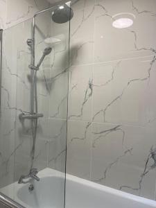 une douche avec une porte en verre à côté d'un lavabo dans l'établissement A beautiful ground-floor flat., à Londres