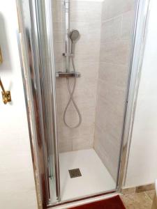 a shower with a glass shower stall with a shower at Appartement DeGaulle in Châteaurenard