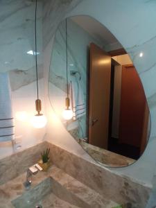a bathroom with a large mirror and a sink at Condomínio encantador de luxo in Goiânia