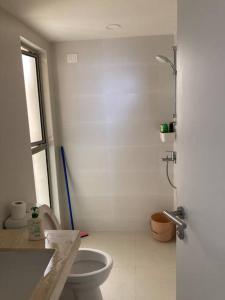 a white bathroom with a toilet and a sink at Private room with air conditioning with private but non-attached bathroom Near airport in Devanahalli-Bangalore
