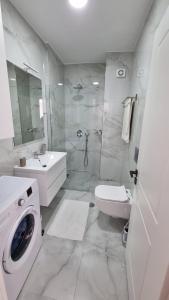 ein Badezimmer mit einem Waschbecken und einer Waschmaschine in der Unterkunft Toni Apartment in Sarandë