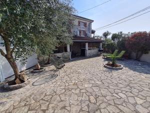 a patio with a chair and trees and a building at Ferienhaus Villa Marein in Poreč
