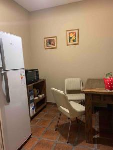a kitchen with a refrigerator and a table with a chair at La Palmera in Deán Funes