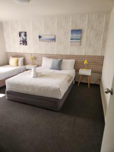 een slaapkamer met een groot bed en een bank bij Amber Court Motel Nelson in Nelson