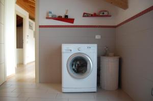 een wasmachine en droger in een wasruimte bij Monferrato Asti-luminosa villa in CastellʼAlfero