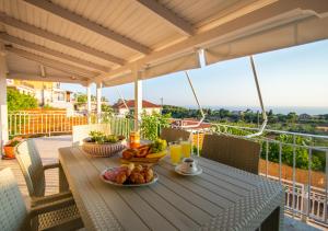 una mesa con comida y bebida en el balcón en The View Villa, en Maryiés