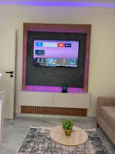 un soggiorno con TV a schermo piatto a parete di ThePlaceForYou Central Apt a Shkodër