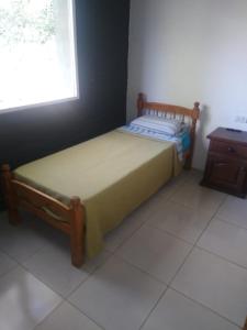 a small bed in a room with a window at Casa de campo Los Cardenales in Rafaela
