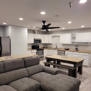 a living room with a couch and a kitchen with a ceiling fan at Pinetop Studio Suites in Pinetop-Lakeside