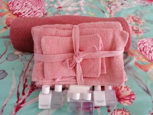 una toalla rosa con un arco encima de botellas de perfume en Proleefic House on Florence en Bellville