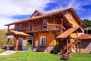 Cette grande maison en bois dispose d'une terrasse couverte et d'un balcon. dans l'établissement Casarão Biazolli, à Farroupilha