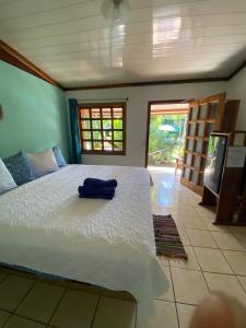 een slaapkamer met een groot bed met een blauwe handdoek erop bij Posada Nena Caribe in Puerto Viejo