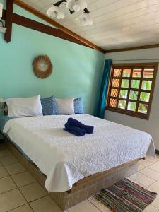 een slaapkamer met een groot bed met witte lakens en een raam bij Posada Nena Caribe in Puerto Viejo