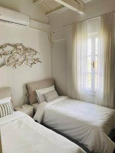 a bedroom with two beds and a window at Spetses Cozy Villa in Spetses +30 photos