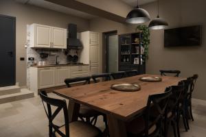 cocina y comedor con mesa de madera y sillas en Rooms "Limes", en Funtana