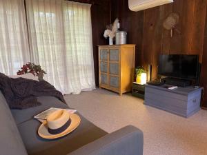 Bilpin的住宿－Browns Cottage，客厅,沙发上挂着帽子